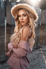 Sensual, attractive and magnificent young woman with long loose blonde hair in a straw hat....