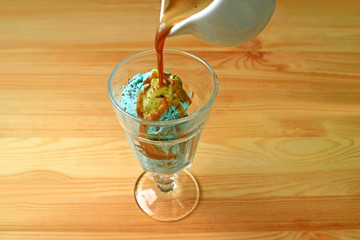 Espresso coffee being poured onto mint chocolate chip ice cream for an Affogato