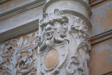 Fototapeta na wymiar Old column with a bas-relief in the form of a demonic face. Kiev, Ukraine