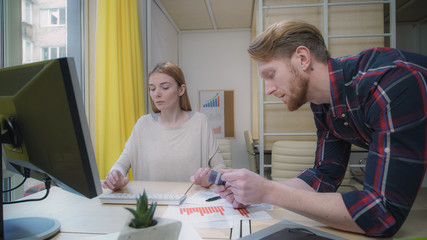 Passive aggressive girl at the computer, a man helps make purchases online. Static video