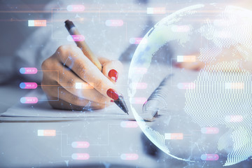 Multi exposure of hands making notes with world map hologram and data theme icons. Concept of global data.