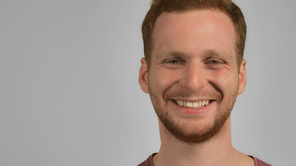 Fototapeta premium Portrait happy man looking at the camera and laughing. Young caucasian guy with red hair and bristle cheerful smile