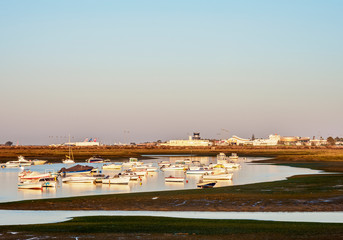 Boats on lagoon at Ria Formosa Natural Park at sunrise, Faro, Algarve, Portugal