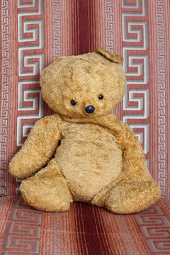 Old teddy bear on color blanket