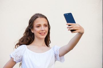 Pretty young brunette woman making selfie on smartphone