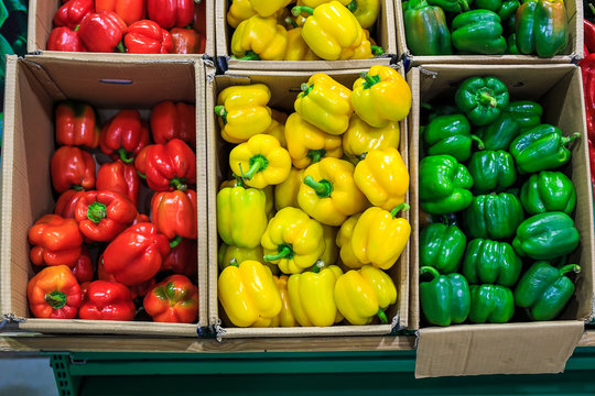 Cardboard boxes with yellow green and red bell peppers in markets