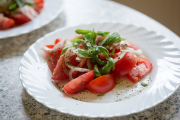 Tomato, onion, basil salad with vinaigrette sauce