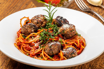 Spaghetti mit Fleischbällchen auf dunklem Holz