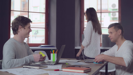 Smiling co workers have fun in the office. Young businessman and businesswoman at work.
