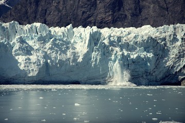 Fototapeta na wymiar Chunk of Ice falling off Glacier, in Glacier Bay National Park and Preserve