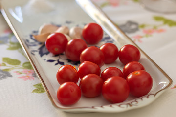 Naklejka na ściany i meble Cherry tomato with garlic on a table