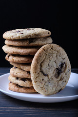 American chocolate chip cookies. Cookies, a glass of milk and a linen towel. Rustic still life.