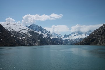 View of Glacier Bay National Park and Preserve from the water, with peaks on both sides. 