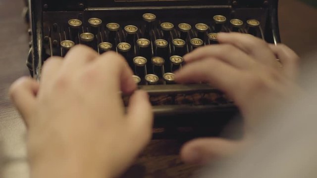 Male hands typing on a printing machine close-up. Old typewriter