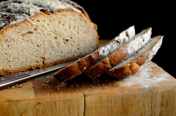 Sliced homemade rustic bread on a wooden table.