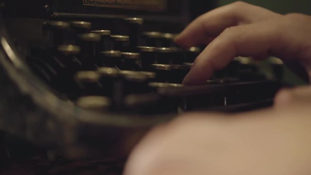 Male hands typing on a printing machine close-up. Old typewriter