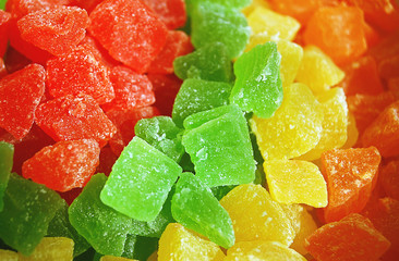 Macro rows of candied colorful ( red, green, orange and yellow) fruits. Pineapple and papaya bits.