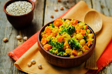 Quinoa broccoli carrot curry on a wood background