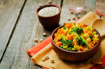 Quinoa broccoli carrot curry on a wood background
