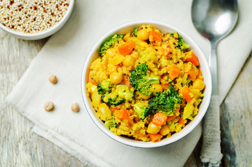 Quinoa broccoli carrot curry on a wood background