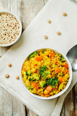 Quinoa broccoli carrot curry on a wood background
