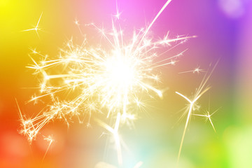 Sparks from hand cold fireworks bright sunspot colorful background