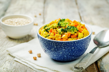 Quinoa broccoli carrot curry on a wood background