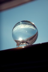 Snow capped mountains in Glacier Bay National Park and Preserve, reflected in crystal ball held by and and