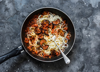Eggplant tomato sauce spaghetti - delicious vegetarian lunch on a dark background, top view