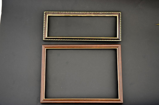 Wooden frame for photos and paintings on a black background with leaves