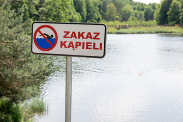 Znak zakazu nad jeziorem. Zakaz kąpieli. - obrazy, fototapety, plakaty