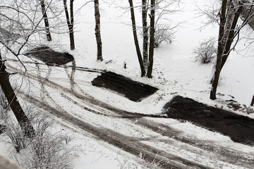 Dark traces of cars on the snow road