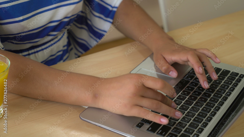 Poster woman's hands computing on computer. woman sitting at the wooden desk with pc and glass with drink o