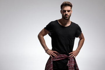 Young casual man holding his hands on his hips