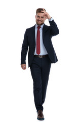 Elegant businessman stepping and gesturing a military salute