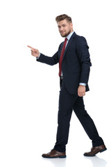 Side view of a handsome businessman stepping and pointing