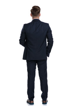 Back view of a young businessman wearing a blue suit