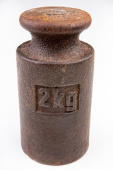 Old weights for weighing on a white table. Steel weights worth 2 kilograms.