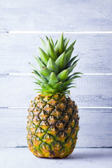 Pineapple on a gray background. Fresh pineapple on a background of boards. Tropical fruit for vegan. Copy space