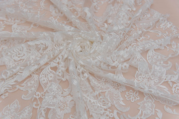 a background image of ivory-colored lace cloth. White lace on beige background.