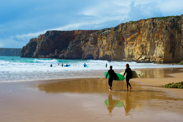 Surfers surfboards beach Portugal cliff