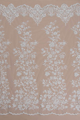 a background image of ivory-colored lace cloth. White lace on beige background.
