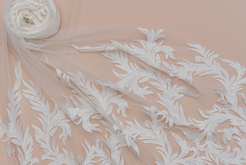 a background image of ivory-colored lace cloth. White lace on beige background.