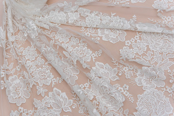 a background image of ivory-colored lace cloth. White lace on beige background.