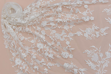 a background image of ivory-colored lace cloth. White lace on beige background.