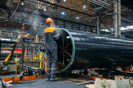 Worker installs clamping ring on coated pipe