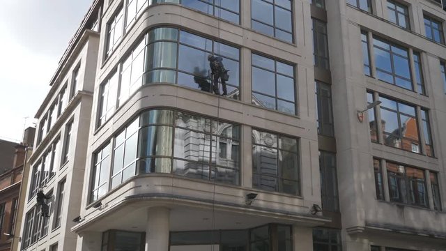 A view of cleaners washing window of an office building.