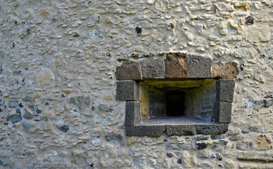 Window in a Medieval fortress or castle, stone wall, offset view.