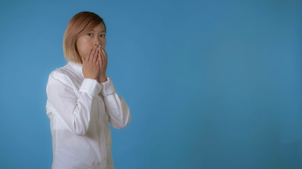 portrait young asian female shows consternation on blue background in studio. attractive korean...