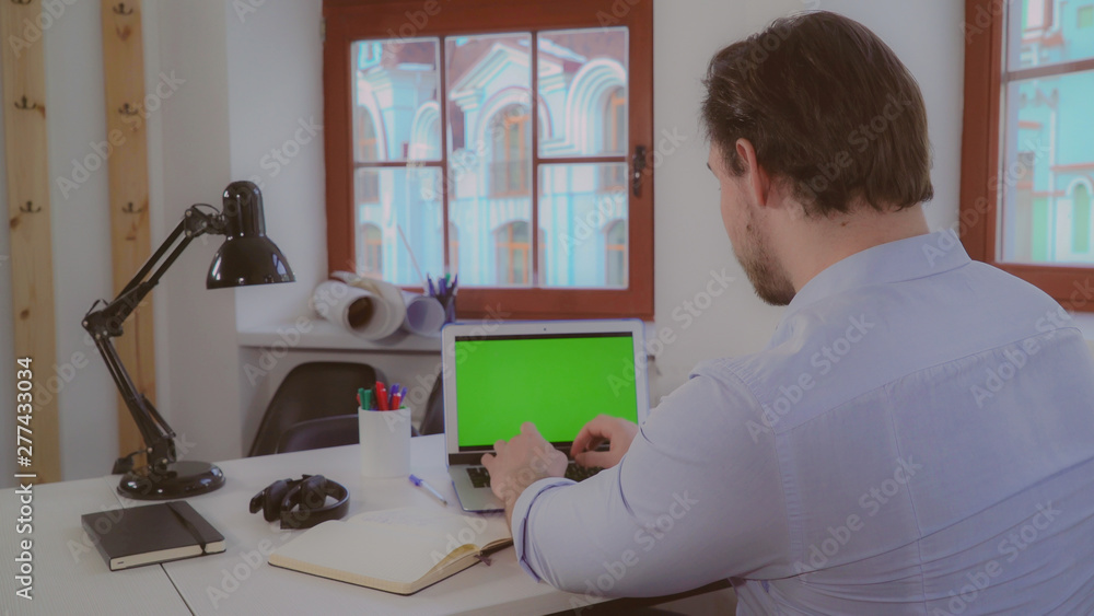 Poster adult man working with computer in the office. businessman sitting at the work place alone near with